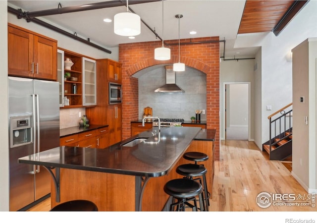 1203 High St, Boulder, CO 80304 - kitchen featuring stainless steel appliances, a sink, wall chimney range hood, dark countertops, and brown cabinetry