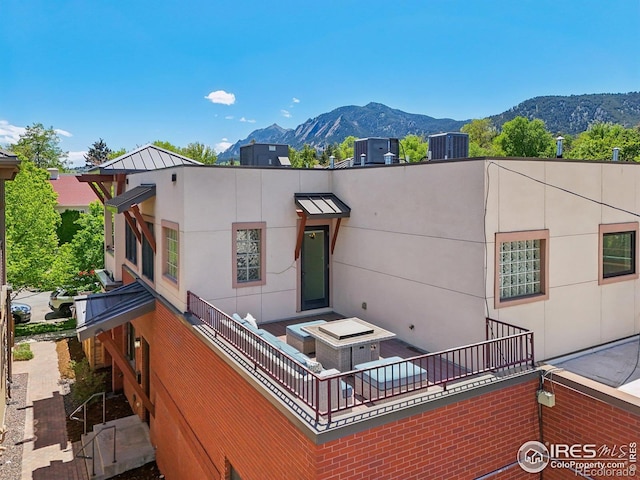 1203 High St, Boulder, CO 80304 - back of house featuring a mountain view, a standing seam roof, central air condition unit, metal roof, and stucco siding