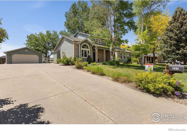 531 S 9th St, Berthoud, CO 80513 - view of front of property with an outdoor structure, a front yard, a detached garage, and brick siding