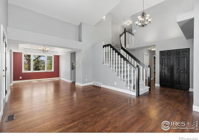 531 S 9th St, Berthoud, CO 80513 - foyer entrance featuring a chandelier, high vaulted ceiling, stairway, and wood finished floors