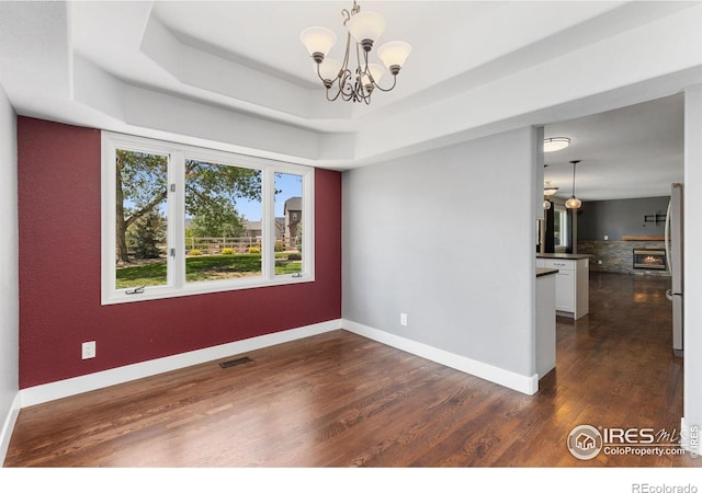 531 S 9th St, Berthoud, CO 80513 - unfurnished room featuring a chandelier, dark wood finished floors, baseboards, and a tray ceiling