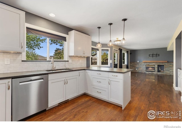 531 S 9th St, Berthoud, CO 80513 - kitchen featuring stainless steel dishwasher, a sink, dark countertops, a peninsula, and decorative backsplash