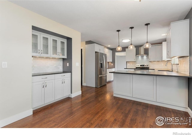 531 S 9th St, Berthoud, CO 80513 - kitchen featuring appliances with stainless steel finishes, wall chimney range hood, decorative backsplash, dark countertops, and a sink