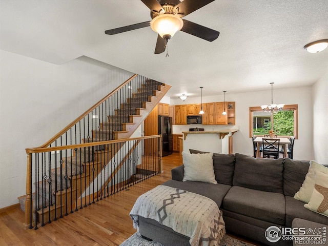 101 SE 2nd St, Berthoud, CO 80513 - living room with wood finished floors, stairs, a chandelier, and a ceiling fan