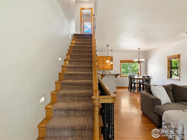 101 SE 2nd St, Berthoud, CO 80513 - stairway featuring wood finished floors and a chandelier