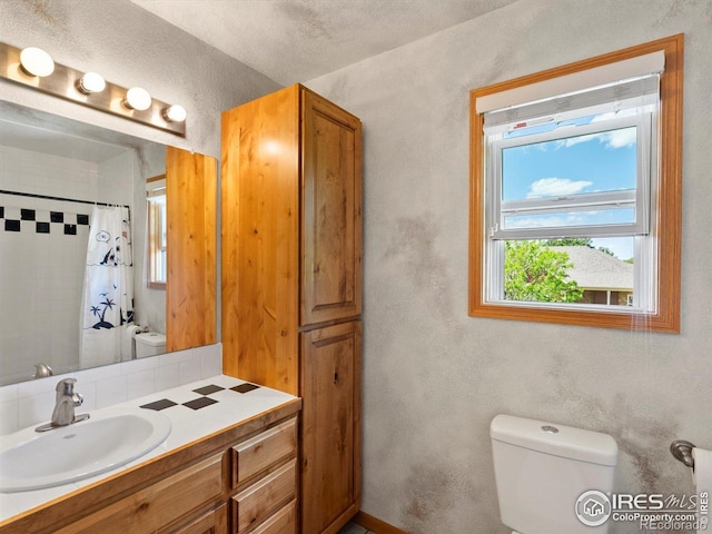 101 SE 2nd St, Berthoud, CO 80513 - bathroom with toilet, vanity, curtained shower, and a textured wall