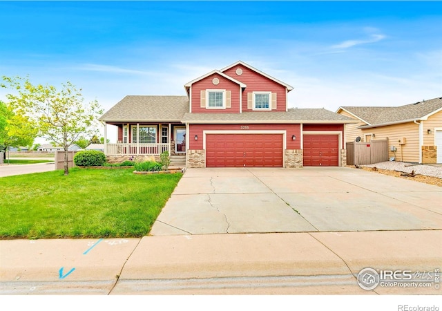 3255 Thundering Herd Way, Wellington, CO 80549 - view of front facade featuring a porch, driveway, stone siding, a garage, and a shingled roof