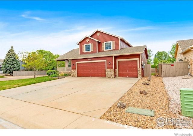 3255 Thundering Herd Way, Wellington, CO 80549 - view of front facade featuring stone siding, driveway, roof with shingles, a garage, and a gate