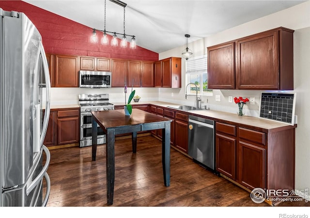 3255 Thundering Herd Way, Wellington, CO 80549 - kitchen with appliances with stainless steel finishes, a sink, lofted ceiling, dark wood-style flooring, and decorative light fixtures