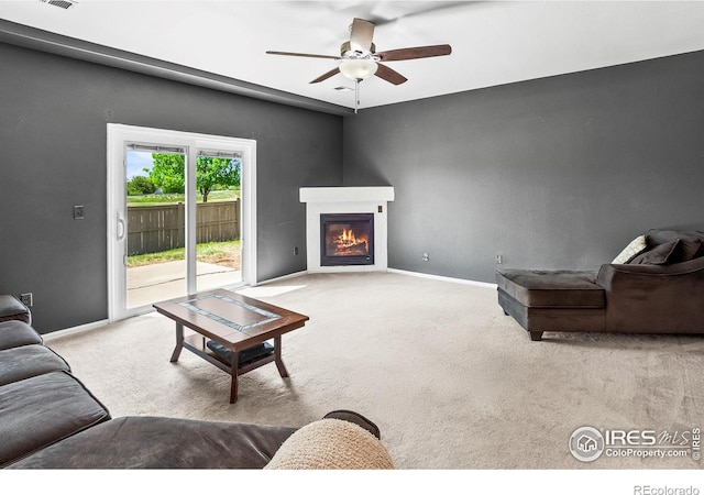 3255 Thundering Herd Way, Wellington, CO 80549 - carpeted living room with a ceiling fan, a warm lit fireplace, and baseboards