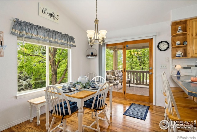 201 Timber Ridge Ct, Severance, CO 80550 - dining area featuring a chandelier, healthy amount of natural light, light wood-style flooring, vaulted ceiling, and baseboards