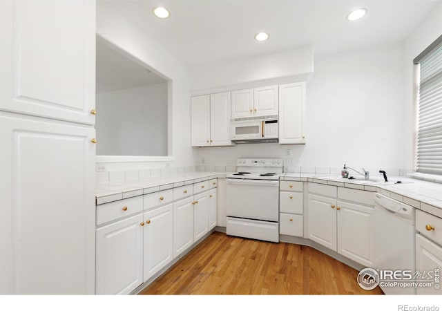 2982 W Long Dr # C, Littleton, CO 80120 - kitchen featuring white appliances, tile countertops, a sink, light wood-style flooring, and white cabinets