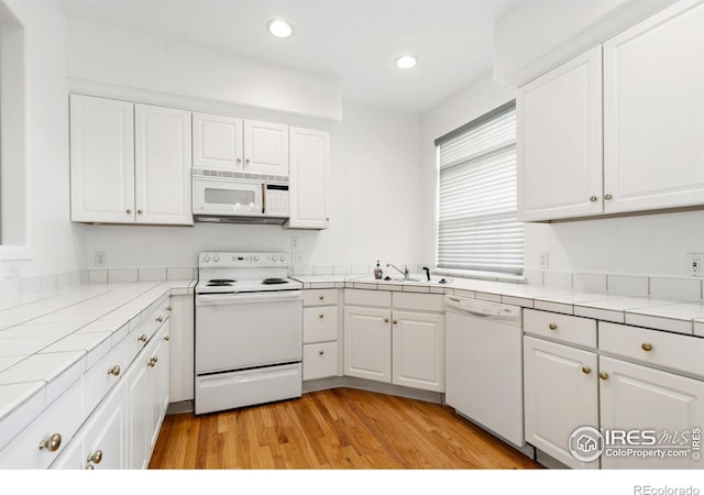 2982 W Long Dr # C, Littleton, CO 80120 - kitchen featuring white appliances, tile countertops, a sink, white cabinetry, and recessed lighting