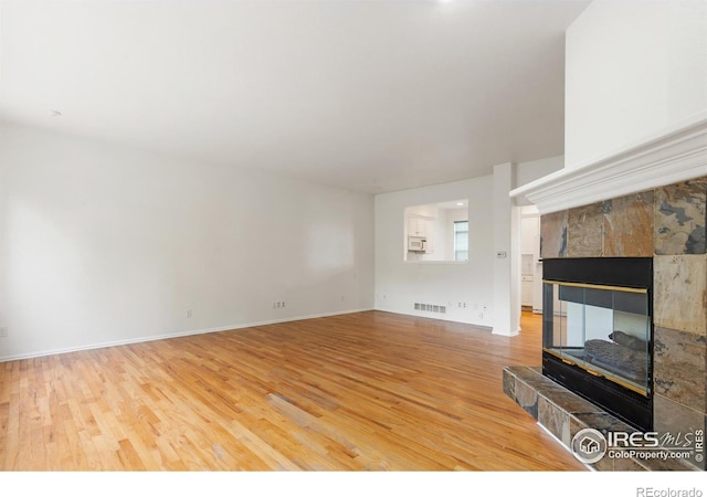 2982 W Long Dr # C, Littleton, CO 80120 - unfurnished living room with wood finished floors, a fireplace, and baseboards