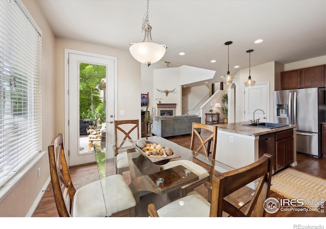 7401 Pimlico Dr, Windsor, CO 80550 - dining space with wood finished floors, a lit fireplace, recessed lighting, and baseboards