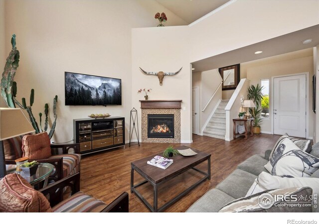 7401 Pimlico Dr, Windsor, CO 80550 - living room with stairs, wood finished floors, a tiled fireplace, baseboards, and recessed lighting