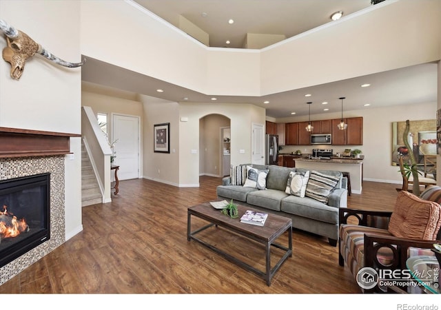 7401 Pimlico Dr, Windsor, CO 80550 - living area featuring dark wood-style flooring, baseboards, arched walkways, recessed lighting, and a fireplace