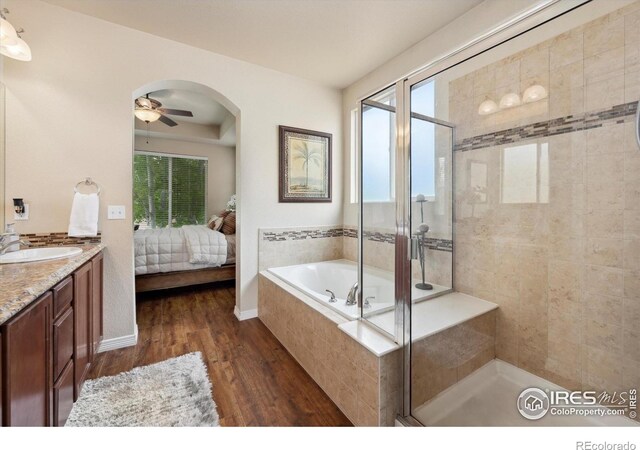 7401 Pimlico Dr, Windsor, CO 80550 - ensuite bathroom featuring wood finished floors, a shower stall, a bath, vanity, and ceiling fan