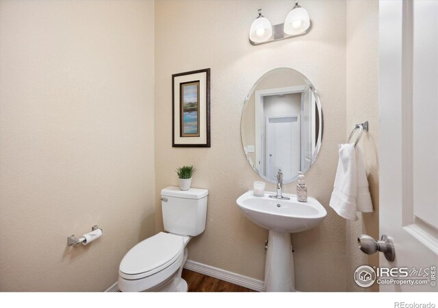 7401 Pimlico Dr, Windsor, CO 80550 - bathroom with toilet, wood finished floors, and baseboards