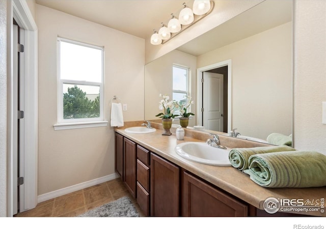 7401 Pimlico Dr, Windsor, CO 80550 - bathroom featuring double vanity, baseboards, and tile patterned flooring