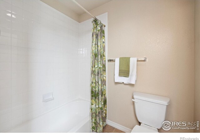 7401 Pimlico Dr, Windsor, CO 80550 - bathroom featuring shower / bathtub combination with curtain, toilet, tile patterned flooring, and baseboards