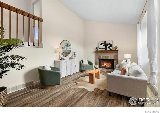 1512 Calkins Ave, Longmont, CO 80501 - living room featuring lofted ceiling, wood finished floors, and a brick fireplace