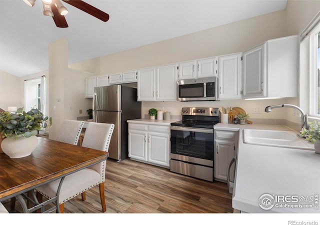 1512 Calkins Ave, Longmont, CO 80501 - kitchen with stainless steel appliances, a sink, light countertops, and white cabinetry