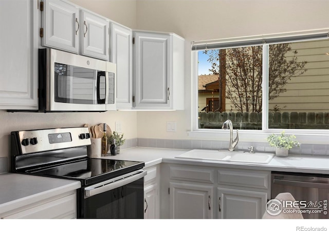 1512 Calkins Ave, Longmont, CO 80501 - kitchen with stainless steel appliances, a sink, white cabinets, and light countertops