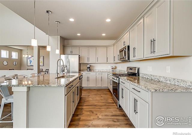 6398 Verna Ct, Timnath, CO 80547 - kitchen with appliances with stainless steel finishes, a sink, recessed lighting, a breakfast bar area, and pendant lighting