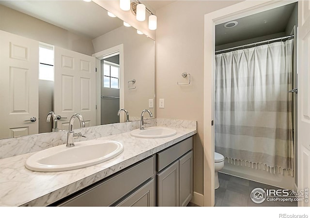 6398 Verna Ct, Timnath, CO 80547 - bathroom with double vanity, toilet, and a shower with shower curtain