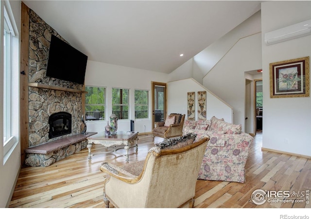 178 Cree Ct, Lyons, CO 80540 - living room with a wall unit AC, wood finished floors, high vaulted ceiling, a fireplace, and baseboards