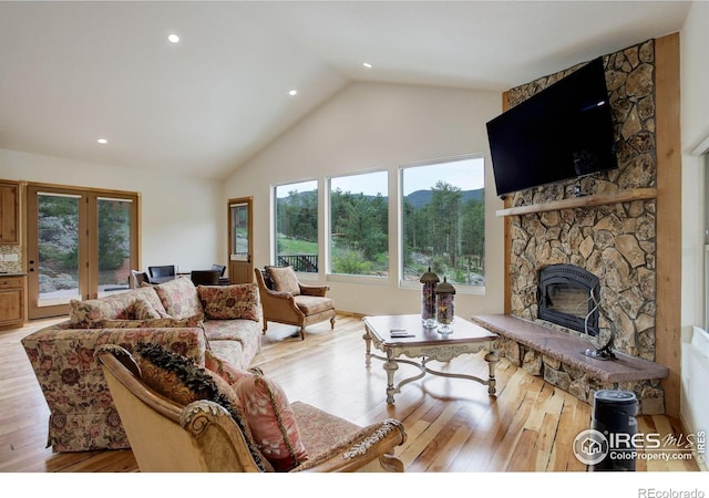 178 Cree Ct, Lyons, CO 80540 - living room featuring a stone fireplace, healthy amount of natural light, french doors, high vaulted ceiling, and light wood finished floors