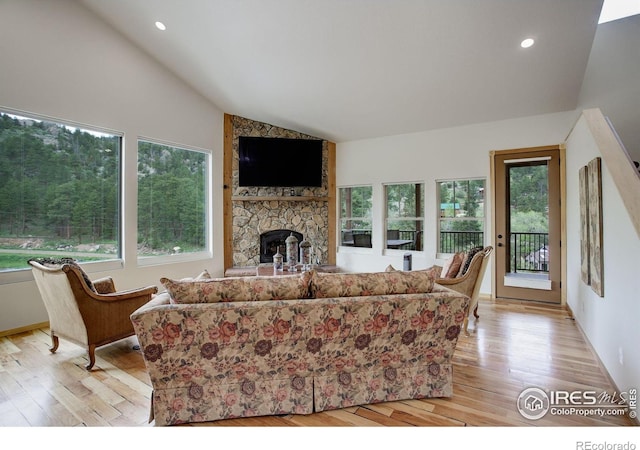 178 Cree Ct, Lyons, CO 80540 - living area featuring lofted ceiling, light wood-style floors, a stone fireplace, and recessed lighting