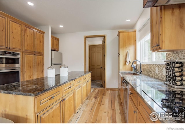 178 Cree Ct, Lyons, CO 80540 - kitchen with appliances with stainless steel finishes, light wood finished floors, a sink, tasteful backsplash, and dark stone counters
