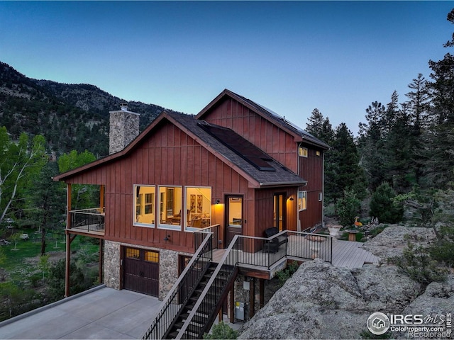 178 Cree Ct, Lyons, CO 80540 - chalet / cabin with driveway, a chimney, a garage, stone siding, and a shingled roof