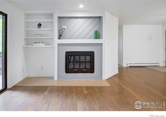 3275 34th St Unit 76, Boulder, CO 80301 - unfurnished living room featuring a baseboard radiator, a fireplace, wood finished floors, built in features, and baseboards