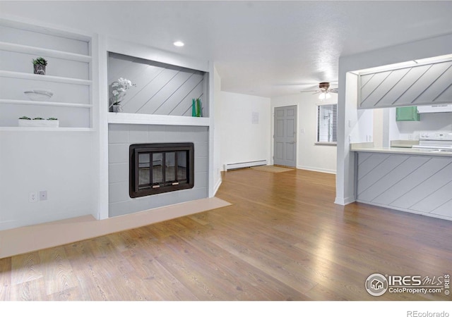 3275 34th St Unit 76, Boulder, CO 80301 - unfurnished living room featuring baseboard heating, wood finished floors, a ceiling fan, a fireplace, and built in shelves