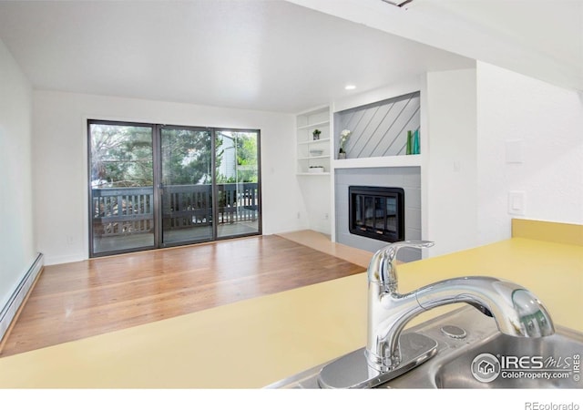 3275 34th St Unit 76, Boulder, CO 80301 - living room featuring baseboard heating, wood finished floors, a fireplace, and built in shelves