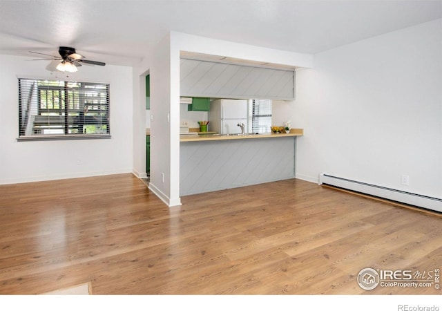 3275 34th St Unit 76, Boulder, CO 80301 - unfurnished living room featuring wood finished floors, a ceiling fan, a baseboard heating unit, and baseboards