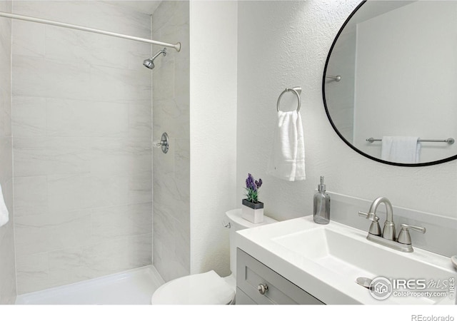 3275 34th St Unit 76, Boulder, CO 80301 - bathroom with toilet, vanity, a tile shower, and a textured wall