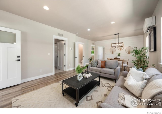 217 Locust St, Windsor, CO 80550 - living room with light wood finished floors, a wall unit AC, a chandelier, recessed lighting, and baseboards