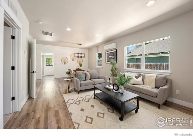 217 Locust St, Windsor, CO 80550 - living area with a wall mounted air conditioner, light wood-style flooring, a chandelier, recessed lighting, and baseboards