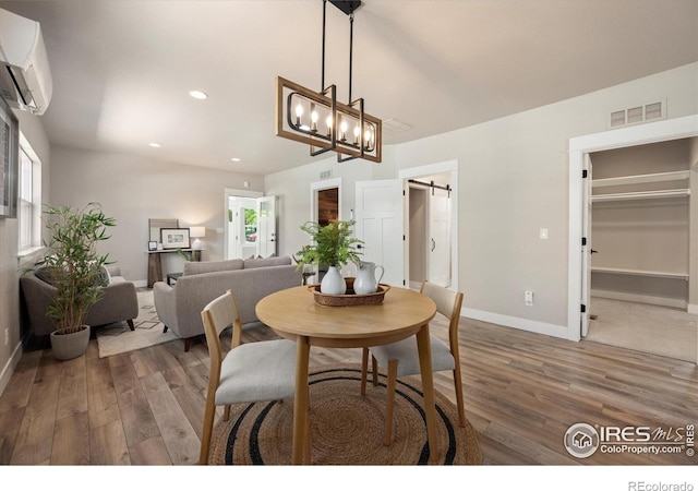 217 Locust St, Windsor, CO 80550 - dining space with a barn door, a wall mounted air conditioner, wood finished floors, baseboards, and recessed lighting