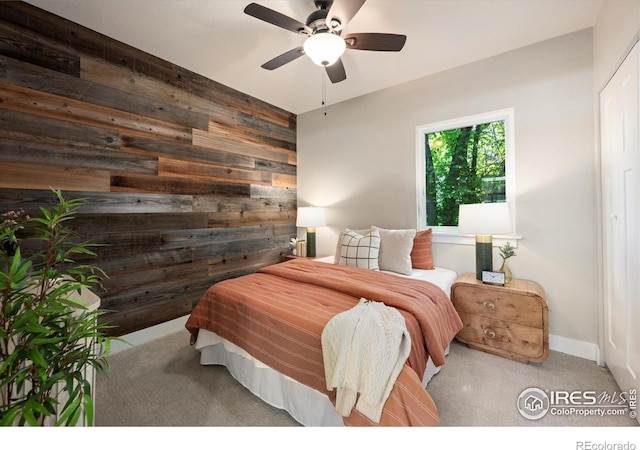 217 Locust St, Windsor, CO 80550 - carpeted bedroom featuring wood walls and a ceiling fan