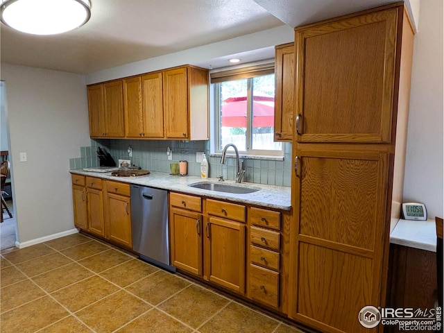 1545 S Vivian St, Longmont, CO 80501 - kitchen featuring stainless steel dishwasher, a sink, brown cabinets, backsplash, and light countertops