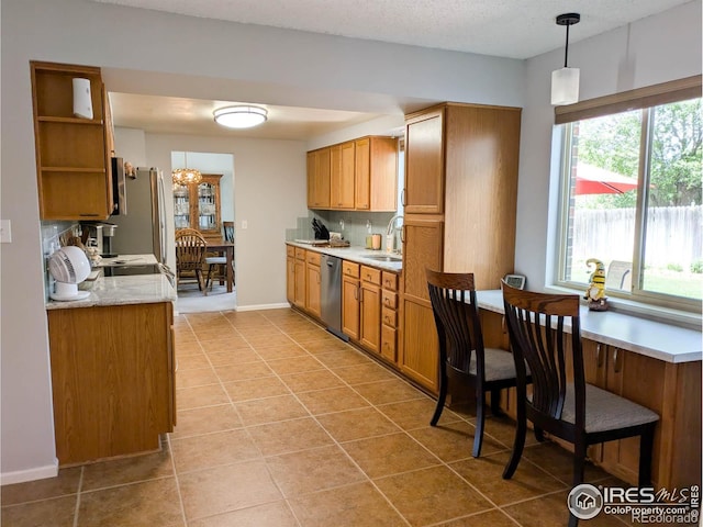 1545 S Vivian St, Longmont, CO 80501 - kitchen featuring appliances with stainless steel finishes, a sink, light countertops, pendant lighting, and open shelves