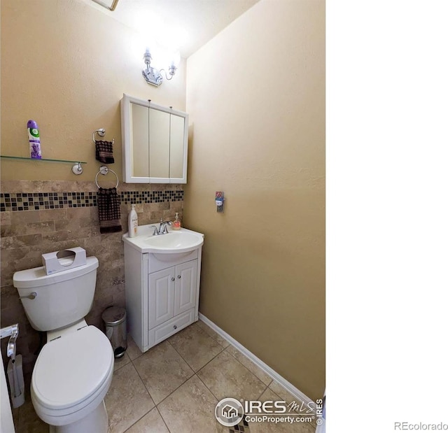 1545 S Vivian St, Longmont, CO 80501 - bathroom featuring tile patterned floors, vanity, toilet, and tile walls