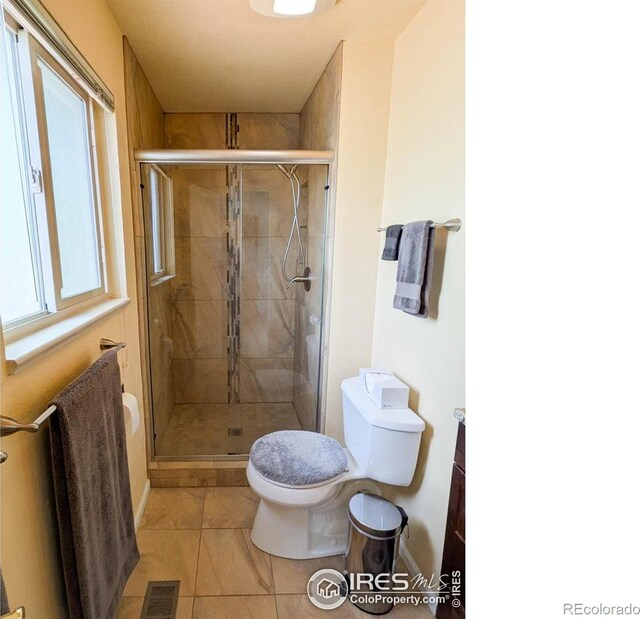 1545 S Vivian St, Longmont, CO 80501 - full bathroom featuring toilet, a stall shower, baseboards, and tile patterned floors