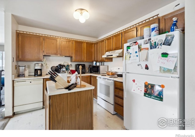 3465 Lochwood Dr Unit N62, Fort Collins, CO 80525 - kitchen with white appliances, under cabinet range hood, light countertops, a center island, and light floors
