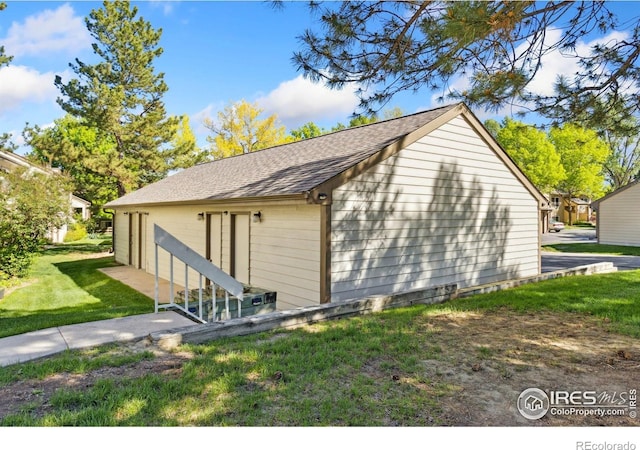 3465 Lochwood Dr Unit N62, Fort Collins, CO 80525 - view of side of property with a lawn, roof with shingles, and a garage